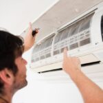 close-up-electrician-repairing-air-conditioner_23-2148087619